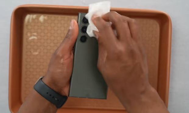 Drying a wet phone with a paper towel before using a water eject app